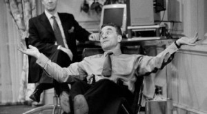 A man reclines in a chair while another man watches - Production shot for Feelgood