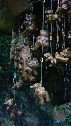 a sculpture of teddy bears hanging from a cave roof