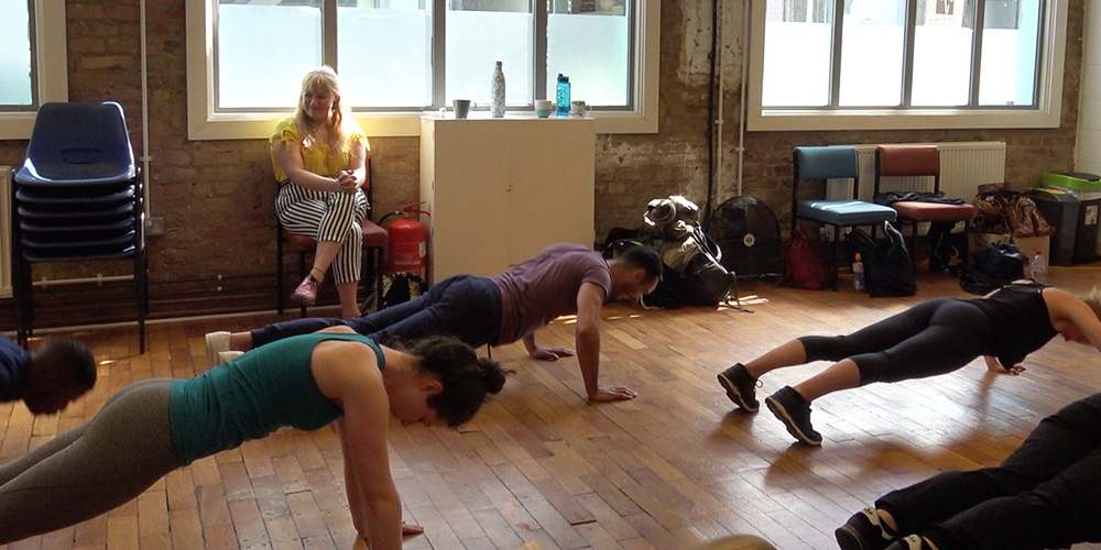 people doing press-ups on a wooden floor